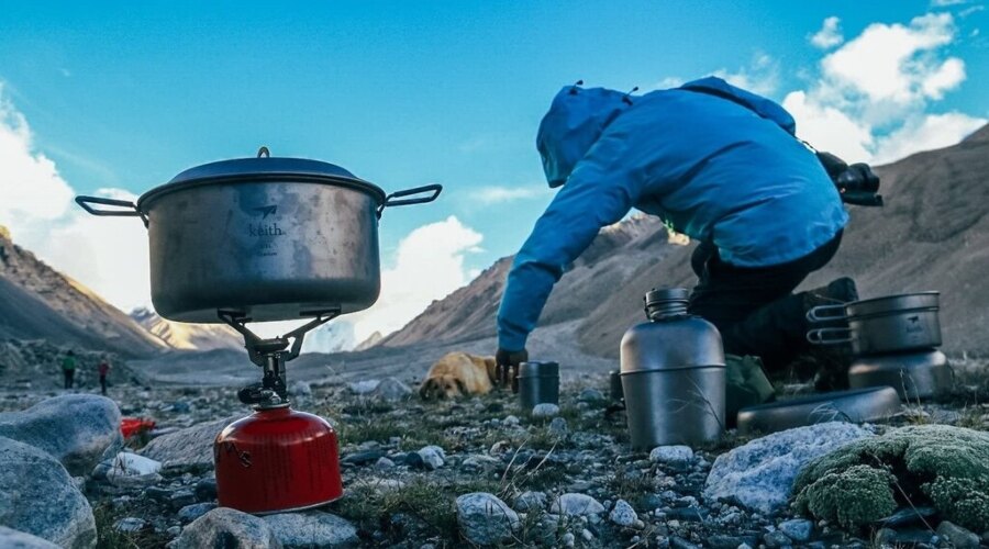 Muž varí v outdoorovom riade