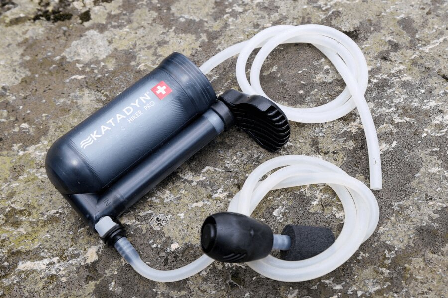 Pumpovací vodný filter Katadyn Hiker Pro s hadičkami položený na kameni. Foto: Rigad