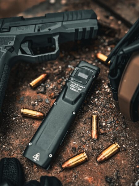 Baterka Nitecore EDC27 UHi s nábojmi a pištoľou v pozadí. Foto: Rigad