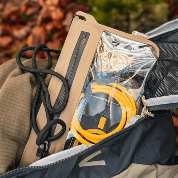 Vodotesný obal Splash Pouch 2.0 Tactical<sup>&reg;</sup> v otvorenom batohu; priehľadné okno s uloženým telefónom a káblom, šnúrka na zavesenie – odolný obal pre outdoor. Foto: Rigad