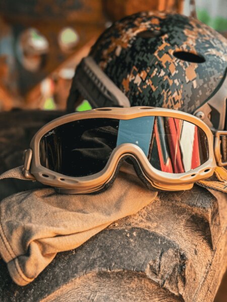 Taktické ochranné okuliare typu goggles položené na výstroju, v pozadí prilba; príklad nasadenia v náročnom teréne. Foto: Rigad