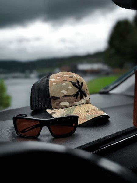 Multicam trucker šiltovka s logom Unity Tactical a strelecké ochranné okuliare na palubnej doske. Foto: Rigad