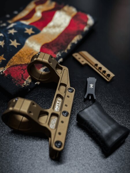 Unity Tactical – modulárna montáž pre optiku vo farbe FDE s príslušenstvom; detail rozhrania pre bočné doplnky a nízky predný úchop (hand stop). Foto: Rigad
