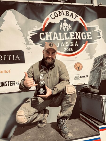 Martin Firych na Combat Challenge Jasná 2025 s trofejou za 2. miesto pred oficiálnym bannerom. Foto: Rigad