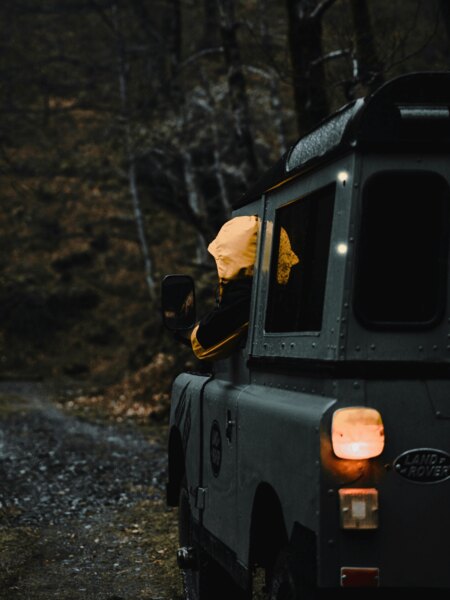 Terénne auto prechádza lesnou cestou za šera, zvýšené riziko stretu so zverou. Zdroj: https://www.pexels.com/cs-cz/foto/osoba-les-vozidlo-rizeni-9258033/