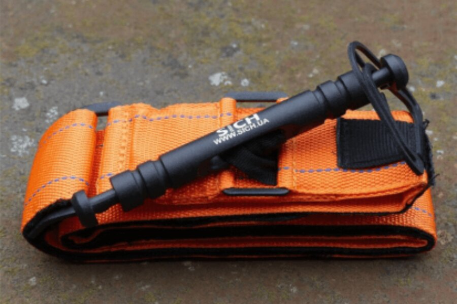 Oranžový turniket SICH s kovovou svorkou a pevnou konštrukciou. Foto: Sich, Rigad