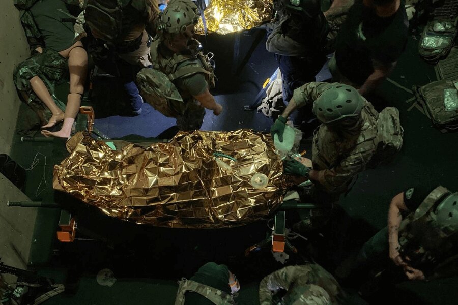 Výcvik taktickej prvej pomoci – tím nacvičuje ošetrenie a transport zraneného zabaleného v termofólii počas simulácie zásahu. Foto: Elite Training Center Lhenice