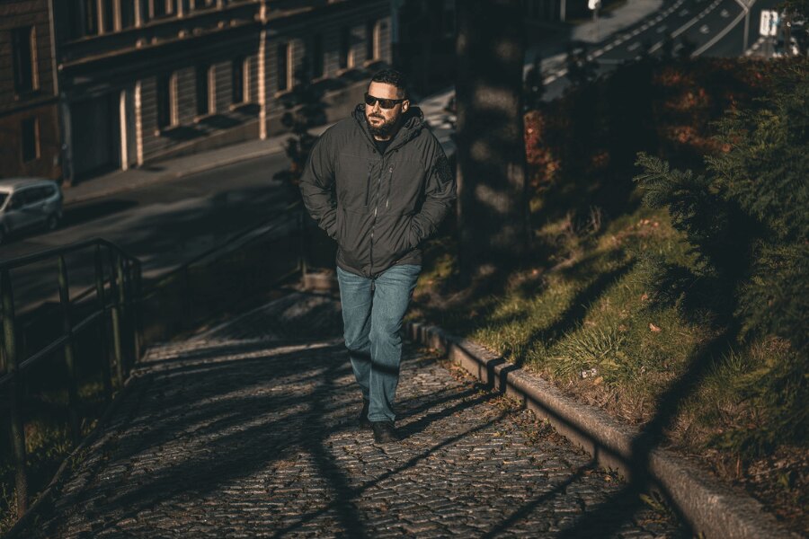 Muž v zimnej bunde Yukon Climashield Apex Helikon-Tex pri chôdzi mestom. Foto: Rigad