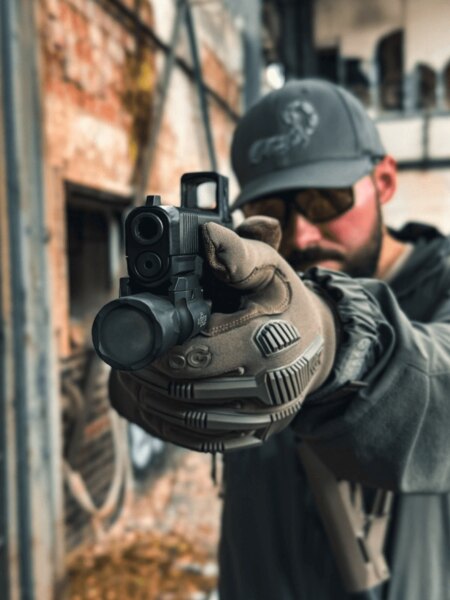 Strelec mieri s pištoľou Glock s kolimátorom Aimpoint COA, pohľad cez zbraň v praxi, Foto: Rigad