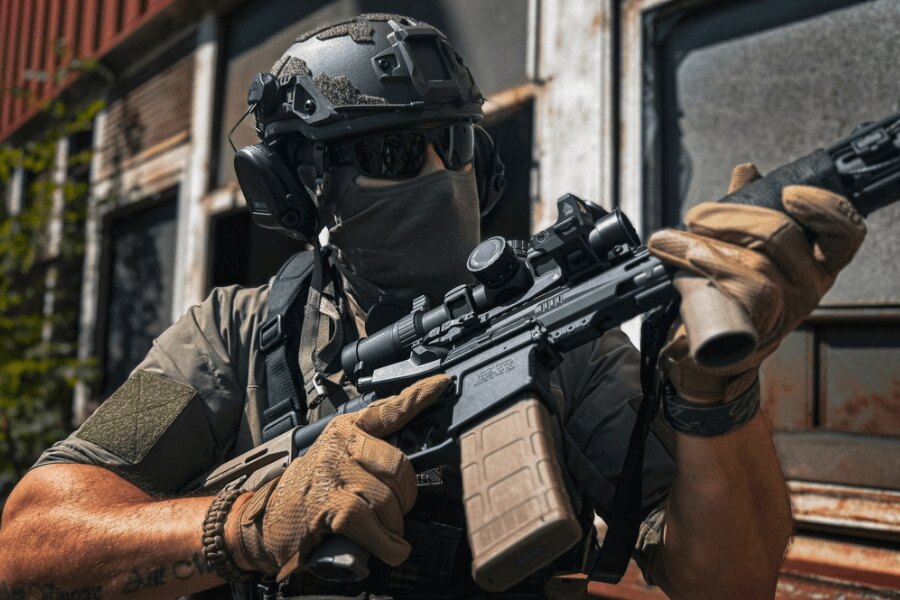 Strelec s puškou AR-15 osadenou optikou pri mierení v teréne. Foto: Rigad