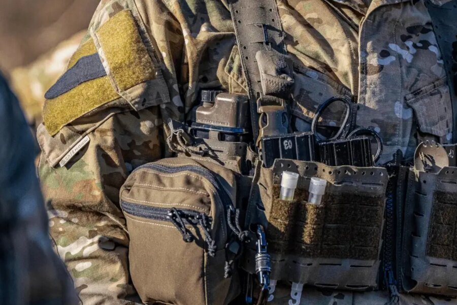 Detail taktického výstroja s hydratačnou fľašou Qore Performance ICEFLASK<sup>®</sup> umiestnenou v nosiču plátov.