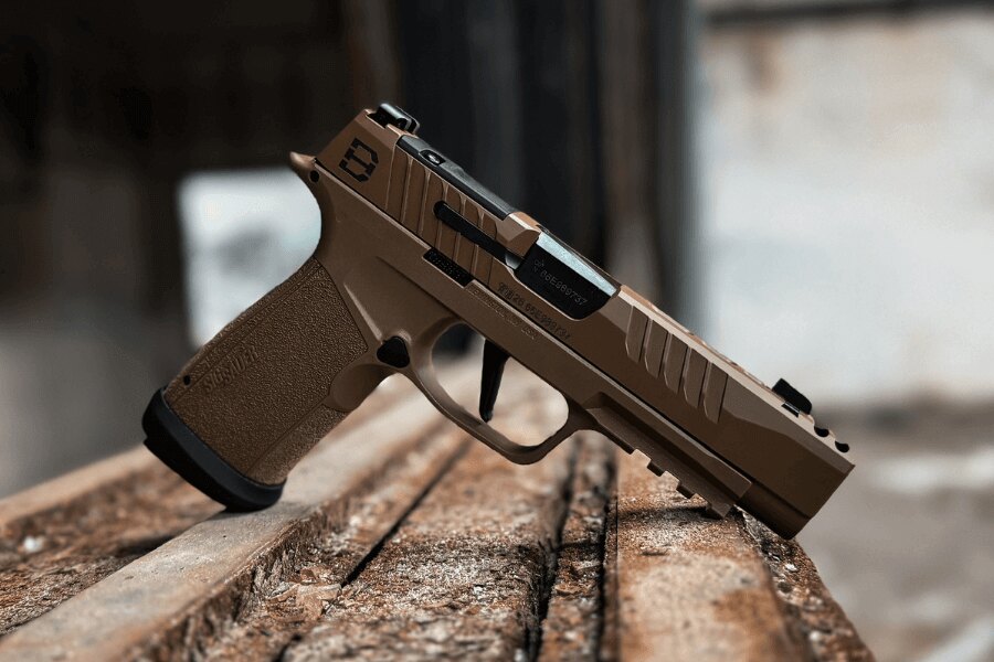 Moderná samonabíjacia pištoľ v kalibri 9 mm Luger položená na drevenom podklade.