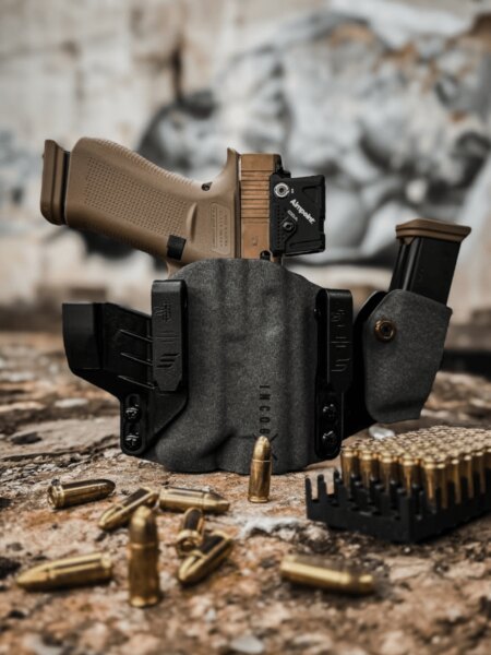 Pištoľ s kolimátorom Aimpoint uložená v puzdre Safariland Incog X s náhradným zásobníkom.