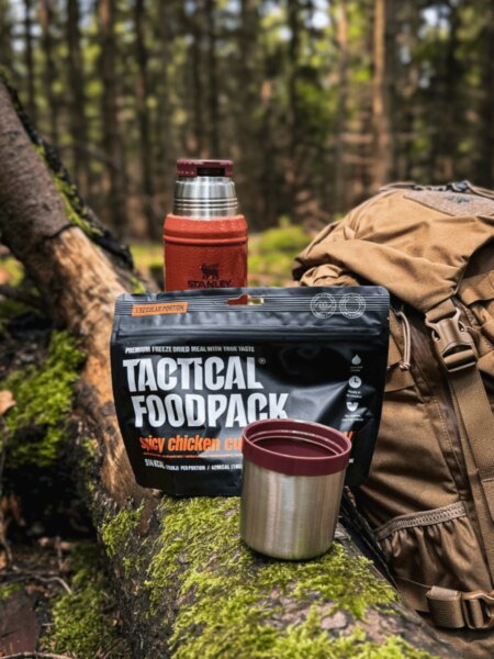 Lyofilizované jedlo Tactical Foodpack s termoskou Stanley, hrnčekom a batohom v lese.