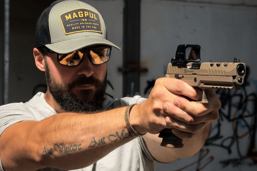 Strelec v ochranných okuliaroch mieri pištoľou SIG Sauer P320 DH3 s kolimátorom Holosun.