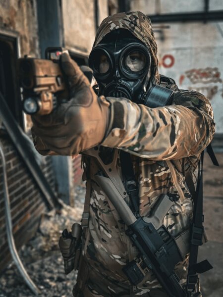 Strelec v celotvárovej ochrannej maske s filtrom pri mierení pištoľou.