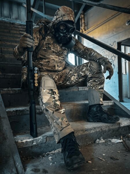 Používateľ v celotvárovej ochrannej maske s filtrom a taktickým výstrojom na schodisku.