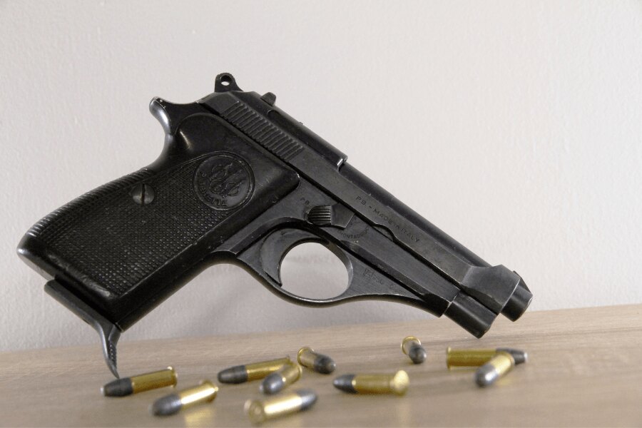 Bočný pohľad na pištoľ Beretta 71 s nábojmi kalibru .22 LR.