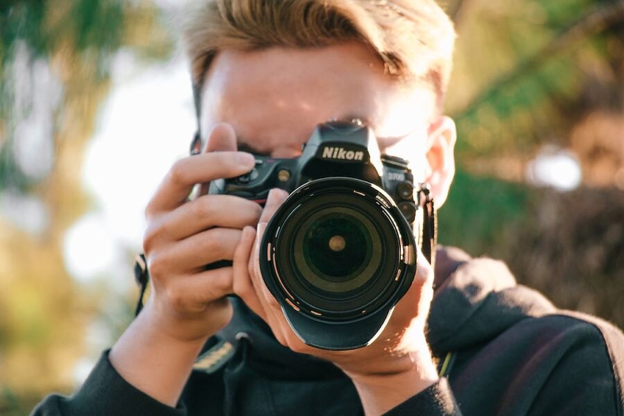 Muž fotiaci s fotoaparátom Nikon