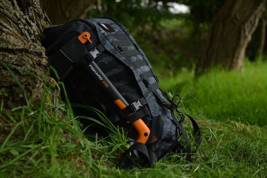 Sekera Fiskars X10 pripevnená na batohu