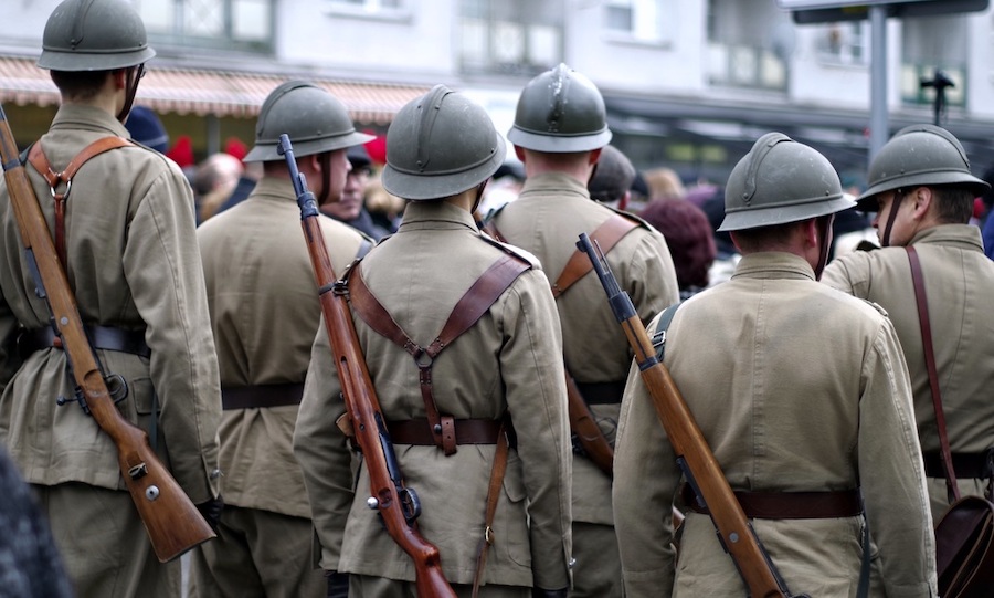 Vojaci v uniforme stojaci medzi ľuďmi.